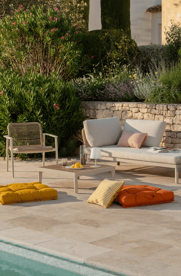 Le salon bas Sollya au bord d'une piscine avec des coussins de couleurs