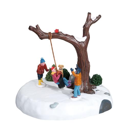 Visuel 1 du produit Scénette pour village de Noël enfants et chien arbre balançoire avec pneu lumineux en résine coloris multicolore à piles Lemax - 16,3 x 17 x 14,5 cm